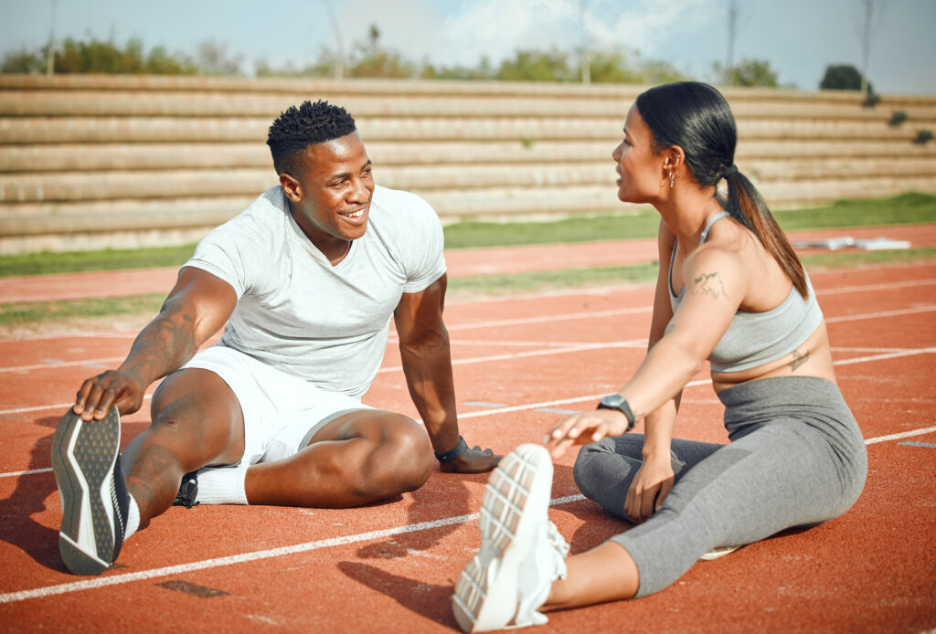 two people warming up before starting their outdoor exercise routine