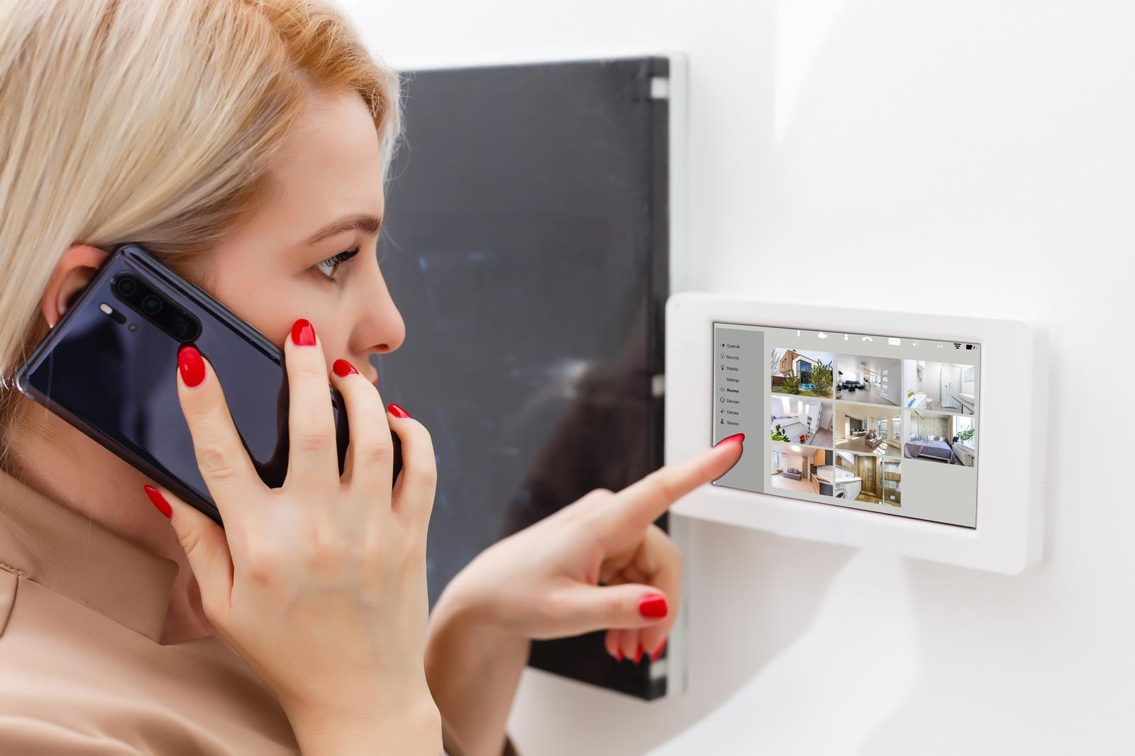 Woman inspecting home security control panel