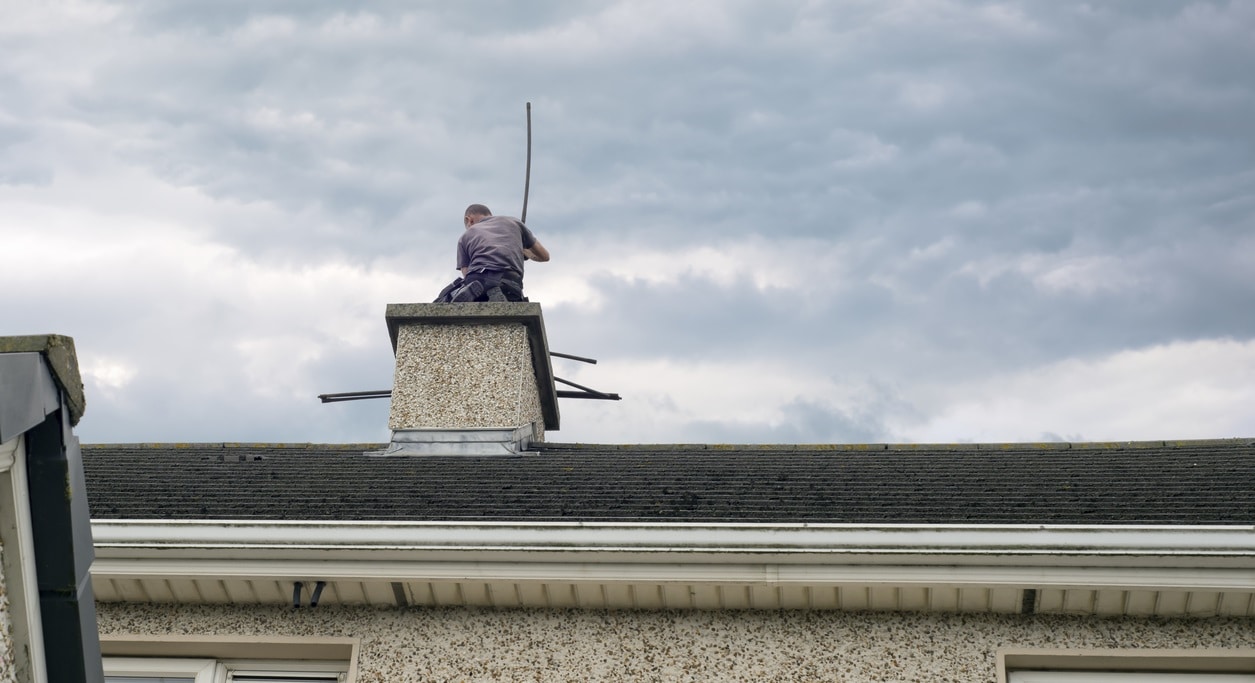 A chimney sweep cleans a home chimney.