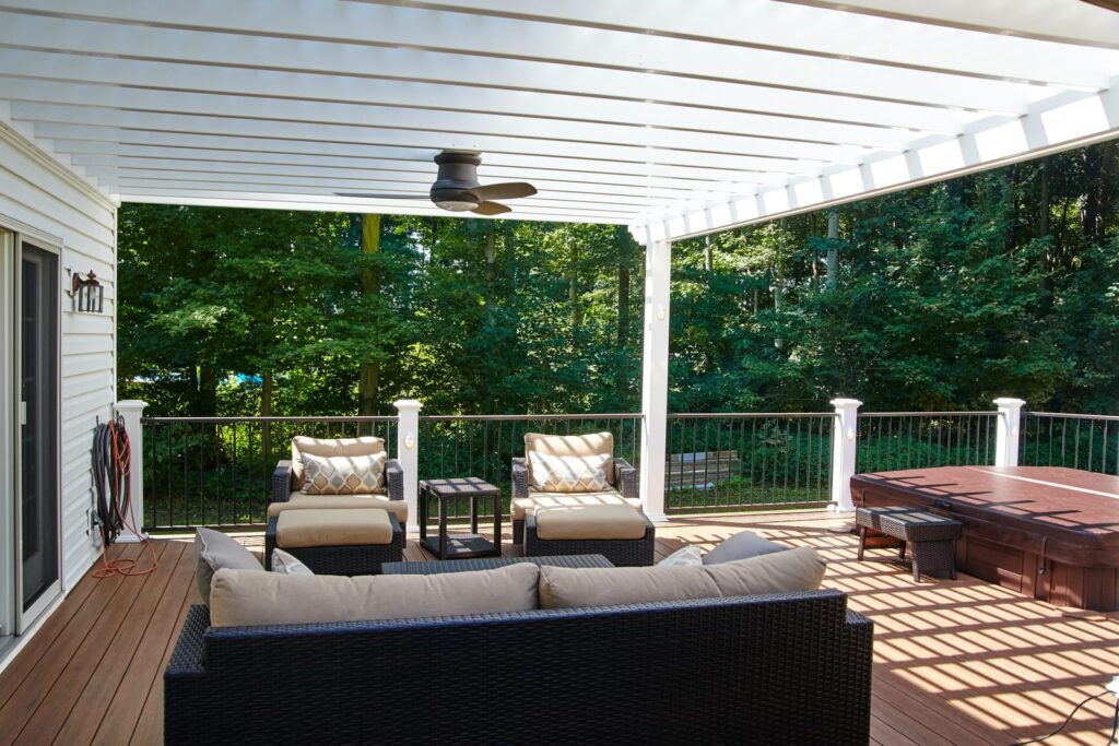 A deck with furniture, pergola and hot tub.