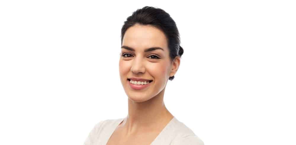 A smiling woman wearing ceramic braces.