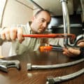 A plumber works on repairing a pipe.