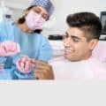 An orthodontist shows an invisalign aligner to a patient.