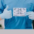 An orthodontist gives a thumbs up as he shows a teeth X-ray at his clinic.