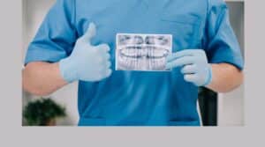 An orthodontist gives a thumbs up as he shows a teeth X-ray at his clinic.