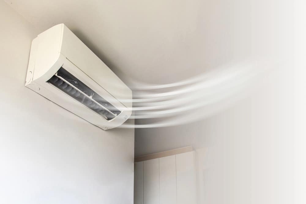 A high-wall heat pump blowing warm air, representing units eligible for the Warmer Kiwi Homes Grant in Palmerston North and throughout New Zealand.